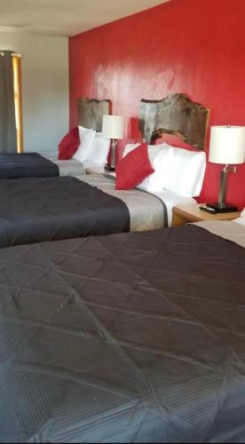 Habitación de hotel con 3 camas y pared roja en Tri-State Wood Inn, en Dickeyville