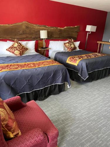 2 camas en una habitación de hotel con paredes rojas en Tri-State Wood Inn, en Dickeyville