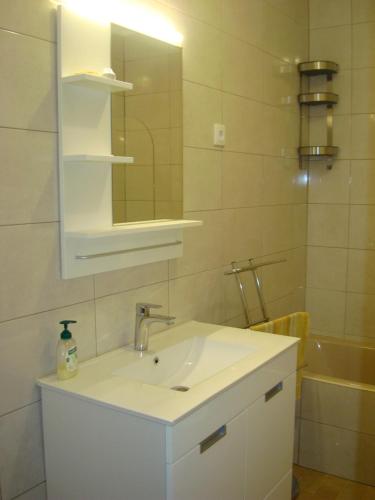 y baño con lavabo blanco y espejo. en Villa T4 35km Montargil - Private & Heated Pool en Casal do Anafe de Baixo