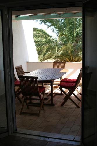 una mesa de madera y sillas en un patio con mesa y sillas en Casa de férias in RETUR, praia do Cabeço, Algarve, en Castro Marim
