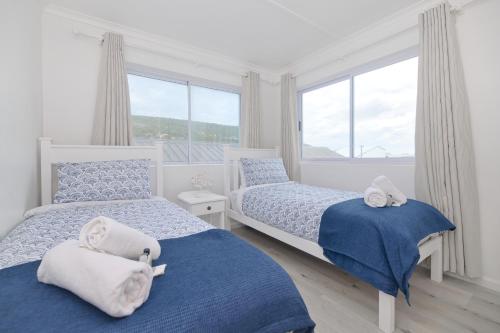 a bedroom with two beds and a window at Beachcombers in Agulhas