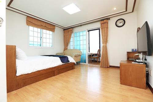 済州市にあるSea Viewのベッドと薄型テレビのある寝室
