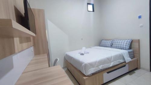 1 dormitorio con 1 cama y TV de pantalla plana en Shofa boarding house syariah, en Jenggrik