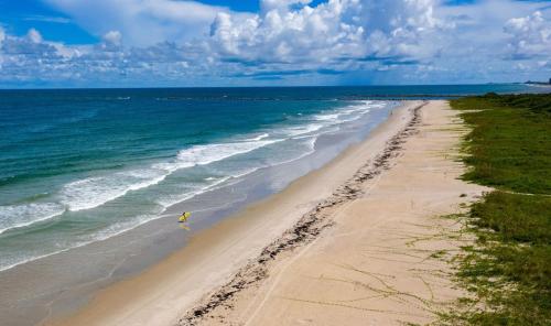 a person walking on a beach with the ocean at Island-Life! A in Fort Pierce
