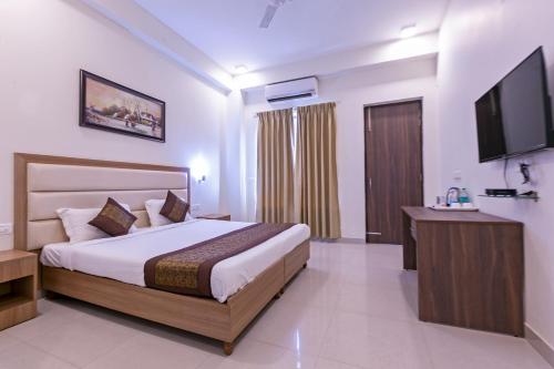 Habitación de hotel con cama y TV de pantalla plana. en Hotel The Luxem - Behind Ibis Hotel Gurugram, en Gurgaon