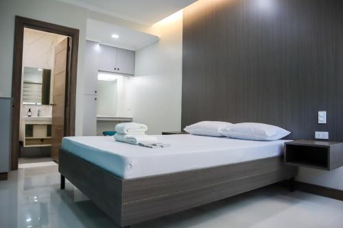 1 dormitorio con 1 cama grande con sábanas y almohadas blancas en The Oregon Hotel and Drive-inn, en Ángeles