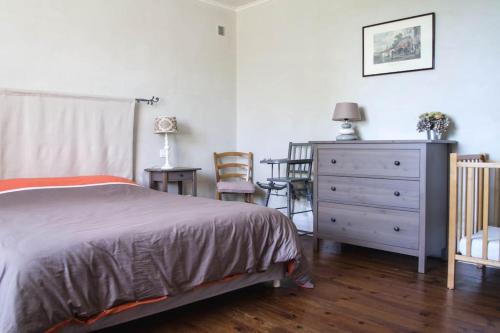um quarto com uma cama e uma cómoda em La Grange de Verseilles em Saint-Étienne-de-Vicq