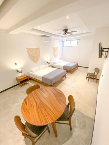 a room with two beds and a table and chairs at Balam Suites in Playa del Carmen