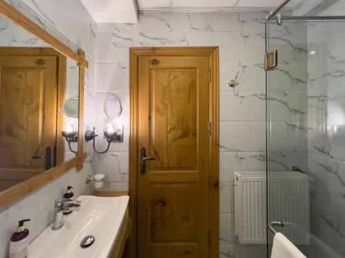 La salle de bains est pourvue d'un lavabo et d'une porte en bois. dans l'établissement Nadis - A handcrafted boutique hotel, à Srinagar