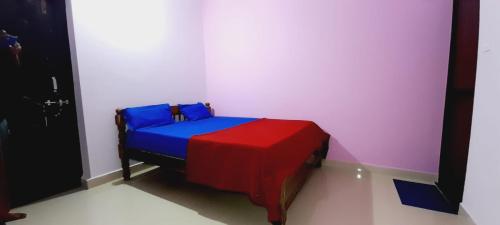 una camera con un letto blu e rosso di Pihu guest house a Calangute