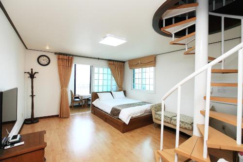 une chambre avec un lit et un escalier en colimaçon dans l'établissement Sea View, à Jeju