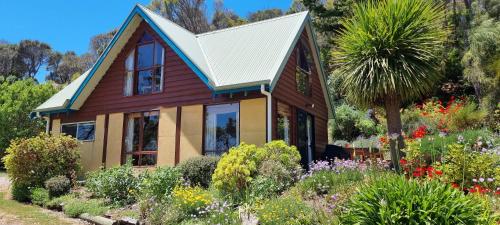 a house with a garden in front of it at Eastern Reef Cottages in Port Campbell