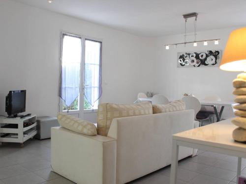 un salon avec un canapé blanc et une table dans l'établissement Charmante maison 6 couchages, jardin privé, proche plage, Wi-Fi, 2 étoiles, ménage inclus - FR-1-246A-155, à Saint-Georges-dʼOléron