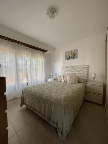 sypialnia z dużym łóżkiem i oknem w obiekcie Departamentos Lidia w mieście Mar del Plata