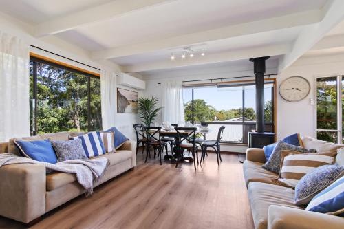 a living room with two couches and a dining room at Fairview Lakeside Cottage Metung in Metung
