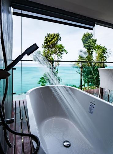 a bathroom with a bath tub with a water fountain at Cliff Lanta Suite-Koh Lanta Krabi in Ko Lanta