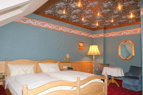 a bedroom with a large bed and a ceiling with a ceiling at Krone am Park - Gästehaus des Hotel Krone in Alzenau in Unterfranken
