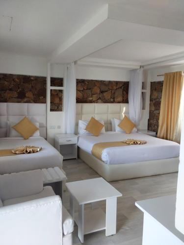 a hotel room with two beds and a table at TAKAWIRI VICTORIA SANDS in Takawiri Island
