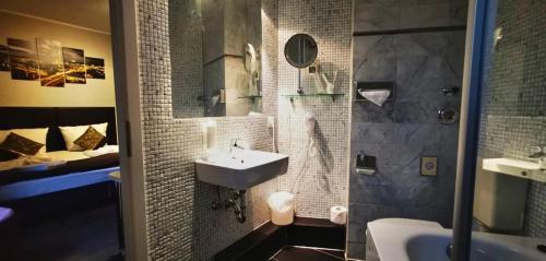 W łazience znajduje się umywalka i prysznic. w obiekcie ALFA Hotel w Berlinie