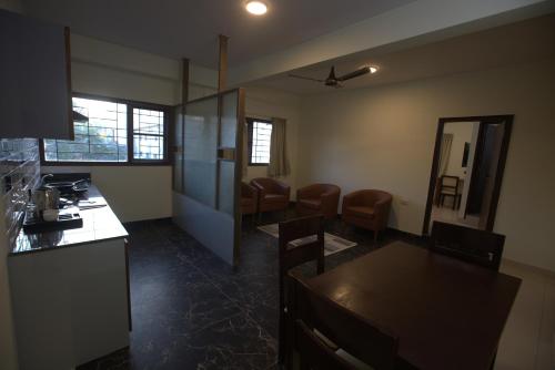 a kitchen and dining room with a table and chairs at Elysian Grand Hotel in Bengaluru