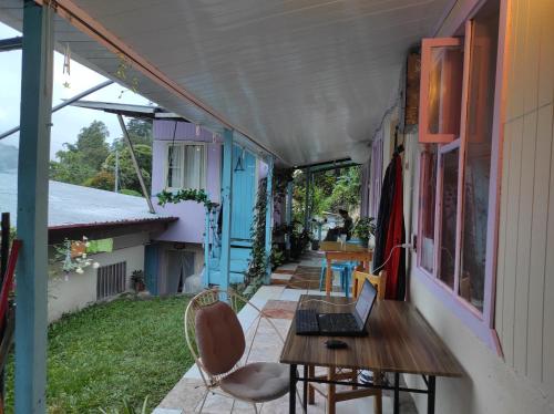 un porche con una mesa y un ordenador portátil. en Alma Double Room Garden View, en Rivas