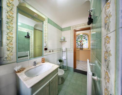 a bathroom with a sink and a toilet and a mirror at La Finestra sul Mare in Ischia