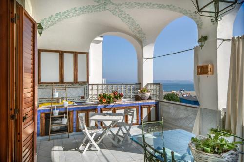 a kitchen with a table and chairs on a balcony at La Finestra sul Mare in Ischia