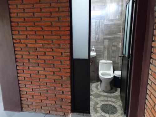 a bathroom with a brick wall and a toilet at Casa Ejutla de Crespo, Oaxaca 