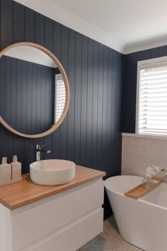 a bathroom with a sink and a tub and a mirror at The Point Lake House in Tiona