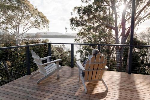 two chairs on a deck with a view of the water at The Point Lake House in Tiona