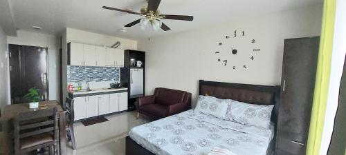 - une chambre avec un lit et une horloge murale dans l'établissement Dracarys 1 Condo complete accomodation Balcony Seaview unli high speed wifi, à Lo-oc