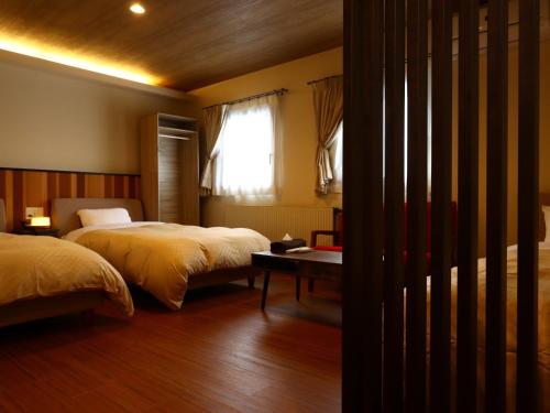 a bedroom with two beds and a window at Villa Monrepos in Myoko