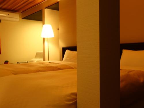 a hotel room with a bed and a lamp at Villa Monrepos in Myoko