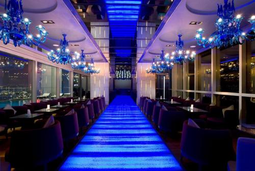 a restaurant with blue lights and tables and chairs at Crowne Plaza Hong Kong Causeway Bay by IHG in Hong Kong