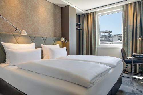 a hotel room with two beds and a window at Motel One München Sendlinger Tor in Munich