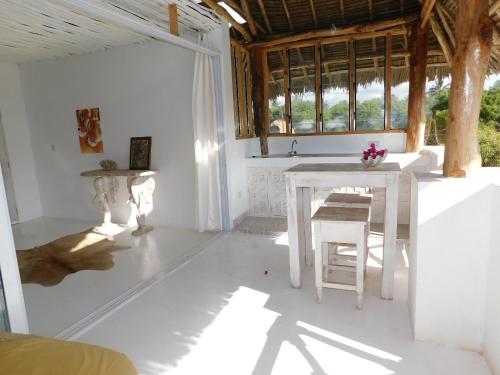 a white room with a table and a window at Dama Villa in Watamu