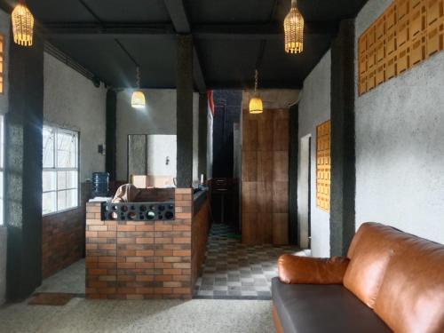 sala de estar con sofá y cocina en Pondok Wisata Syariah Deporiz en Kadudampit