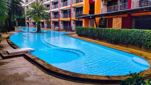a large blue swimming pool next to a building at MBC Mai Khao Beach Condotel LUXURY APARTMENTs in Phuket Town