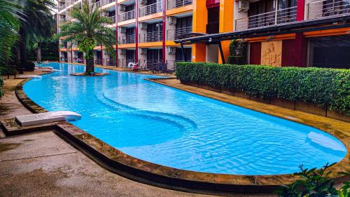 een groot blauw zwembad naast een gebouw bij MBC Mai Khao Beach Condotel LUXURY APARTMENTs in Phuket