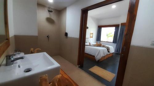 a bathroom with a sink and a bed and a mirror at Blue Marlin Air in Gili Islands