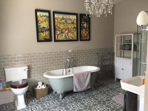 a bathroom with a bath tub and a toilet at Beautiful Georgian House located in Blandford in Blandford Forum