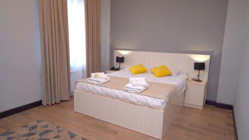 a bedroom with a bed with towels on it at Edem Hotel Shymkent in Shymkent