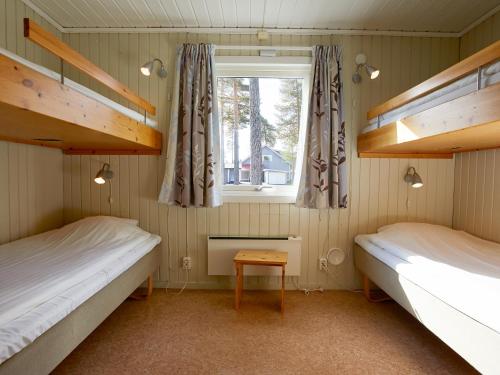 two beds in a room with a window at First Camp Ansia - Lycksele in Lycksele