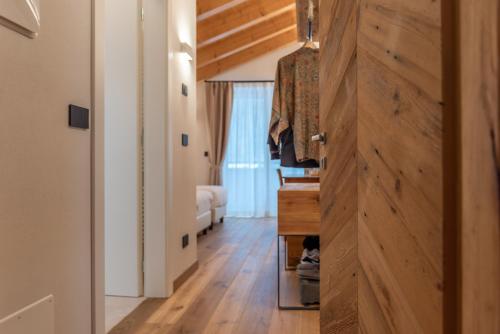 a hallway with a wooden door and a bedroom at B&B El Lares - B&B L'Avez in Canale dʼAgordo