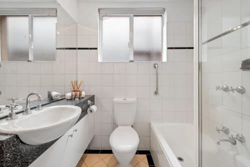 a bathroom with a sink and a toilet and a shower at StayCentral - Brunswick Vibe Parkville in Melbourne