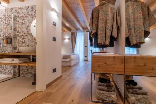 a room with wooden ceilings and a hallway with clothes hanging on hooks at B&B El Lares - B&B L'Avez in Canale dʼAgordo
