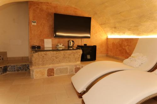 une chambre d'hôtel avec un canapé et une télévision dans l'établissement La Dimora del Principe, à Grottaglie