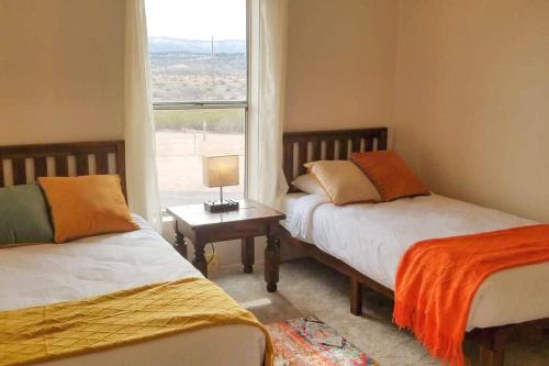 1 Schlafzimmer mit 2 Betten und einem Fenster in der Unterkunft Desert Hillside Lodge 25 mins from Sedona in Cornville