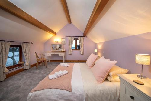 a bedroom with a large bed with pink walls at The Owl House with private hot tub in Newport