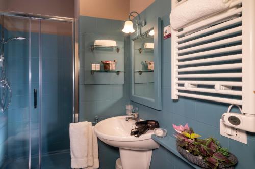 a blue bathroom with a sink and a shower at Quadra Key Easy Home In Florence in Florence